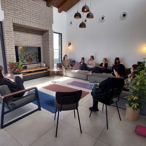 קבוצה של נשים יושבות בסלון ועוברות הדרכה של תזונה נכונה