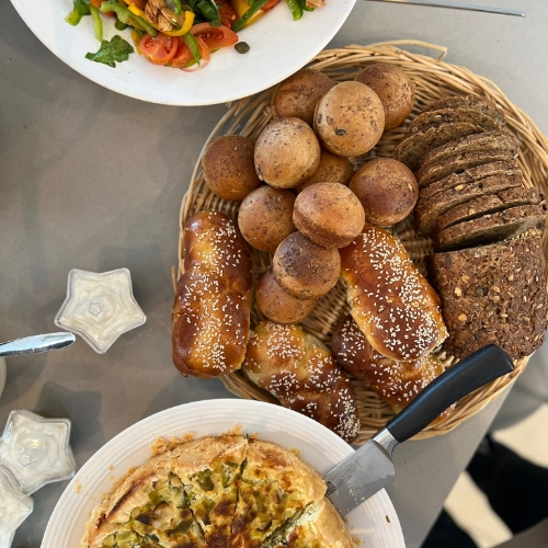 תמונה של ארוחה בצלחות שונות כמו קערות בצורה כוכב והאוכל על השולחן פשטידה סלט לחמים