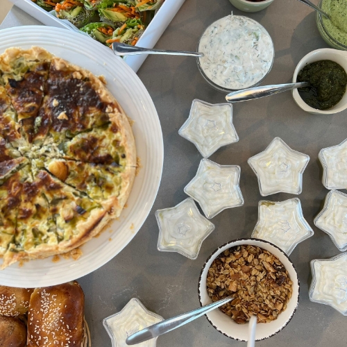 תמונה של ארוחה בצלחות שונות כמו קערות בצורה כוכב והאוכל על השולחן פשטידה דגני בוקר לחמים רטבים